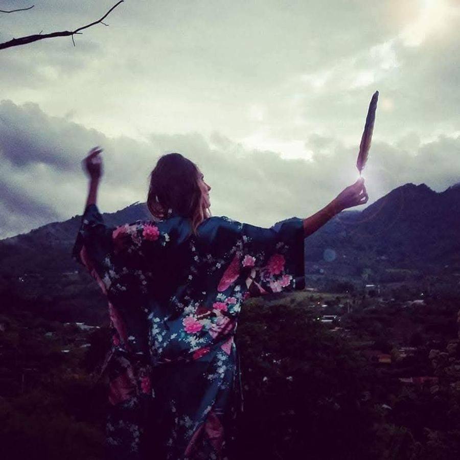 Michela raising a feather to the sky — Air Session