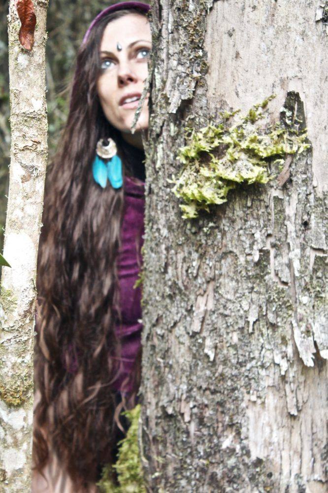 Michela peeking from behind a tree trunk — Cammina con l'Elfo