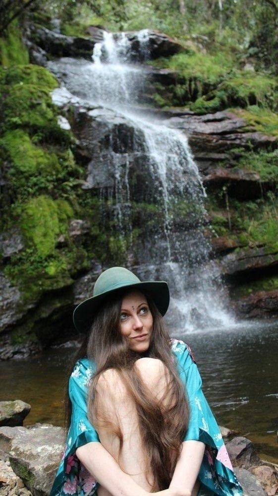 Michela beneath a waterfall, seen from behind